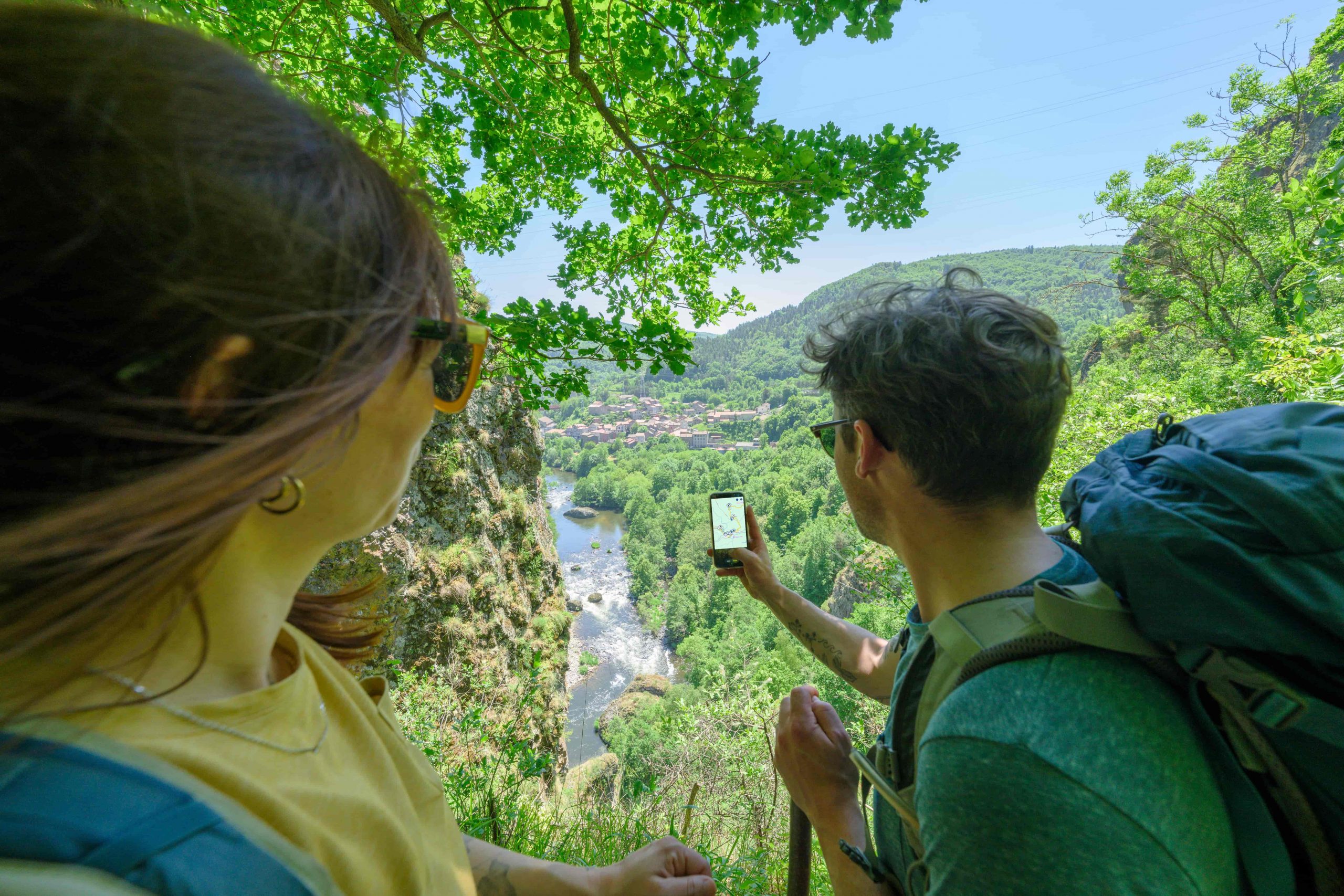 Deux randonneurs cherchent leur chemin sur une application mobile du GR65.